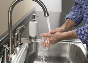 Primer plano de manos que se lavan en un lavabo debajo del chorro de agua.